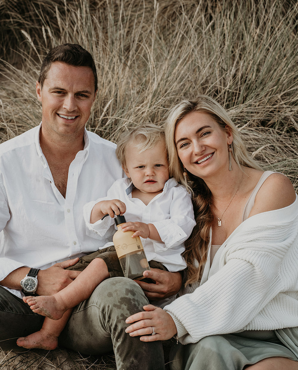 Edward and Dasha, the founders of the natural skincare brand, Wild England sat in the dunes of Lulworth Cove, Dorset