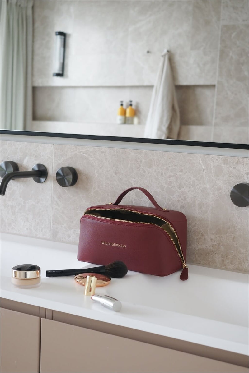 Wild Atelier Special Edition Leather Travel Case sat on bathroom sink with make up brushes and lipstick