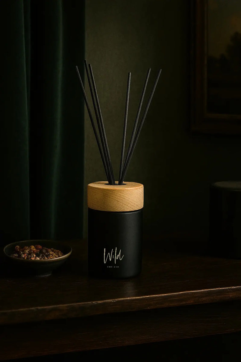 Cumin and Tobacco Reed Diffuser lifestyle shot on rustic wooden table top next to bowl of dried fruits