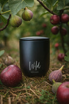 Black Fig and Vetiver Limited Edition Candle sat amongst fig trees with figs on the ground