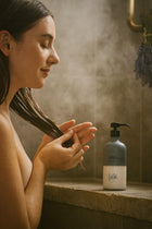 Wild England natural conditioner lavender and eucalyptus 475ml bottle being applied to hair by model in shower
