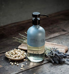 Wild England natural hand and body wash lavender and eucalyptus almost 475ml bottle next to dried lavender on a rustic wooden surface