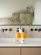 Wild England natural sweet and orange cardamom hand and body wash and lotion 475ml bottles placed in luxury bathroom